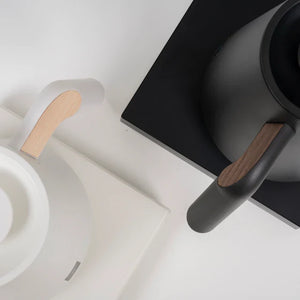 Detaljbilde av svart og hvit elektrisk vannkoker med tre detaljer for barista- og bryggtilbehør fra Timemore